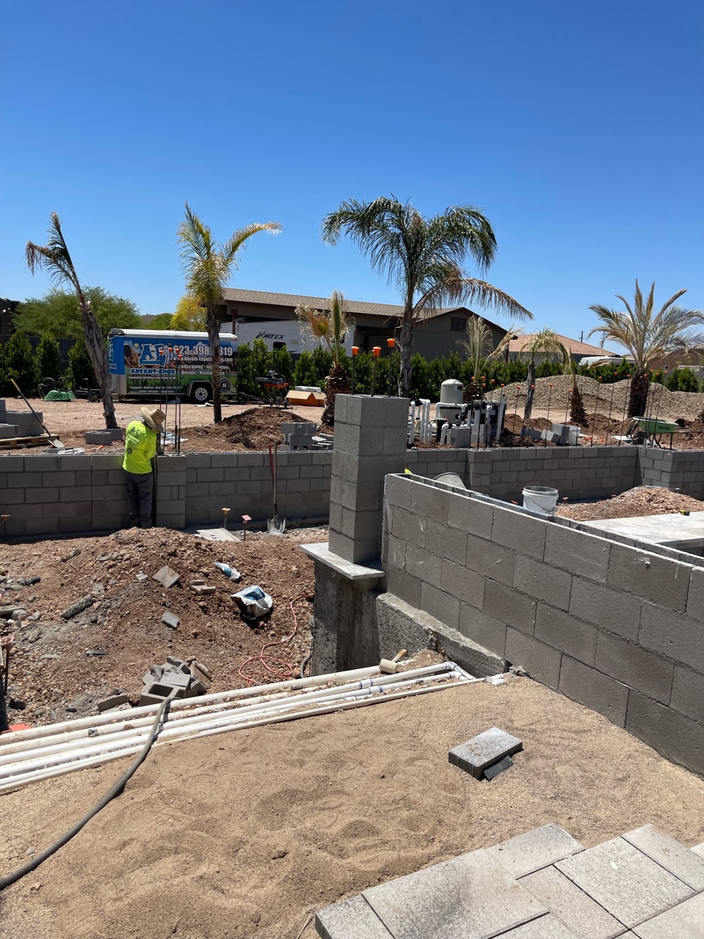 Aurora Estate — block wall and structural column piers built up around the pool shell with equipment lines and site grading still exposed