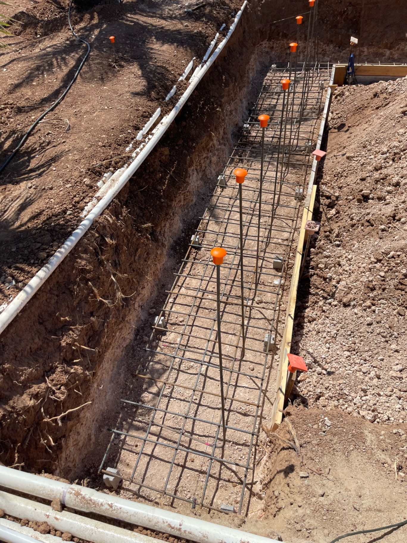 Aurora Estate — close view down the reinforced trench showing steel layout, depth, and formwork before concrete placement
