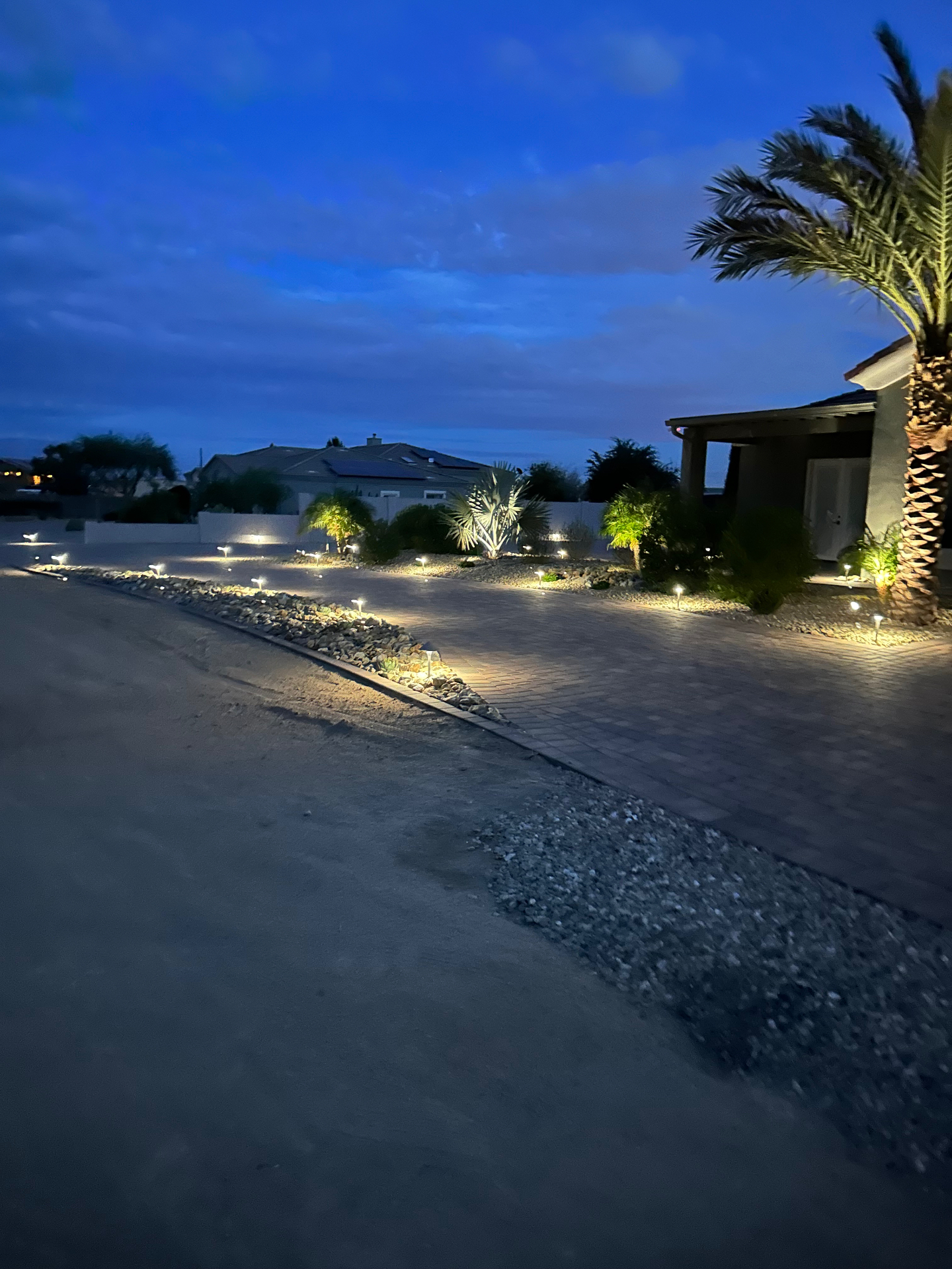 Aurora Estate — river-rock rivulet between paver islands at dusk