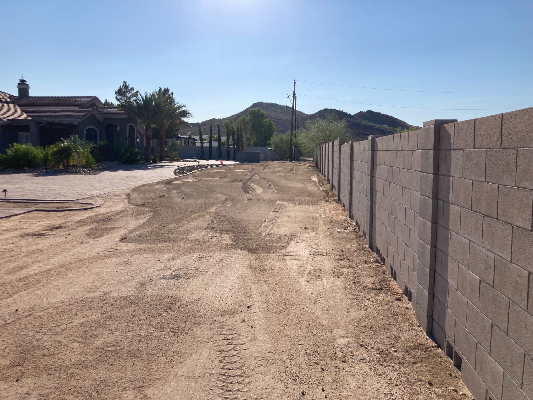 Aurora Estate — front yard graded and prepped along the perimeter block wall before pavers and lighting were installed