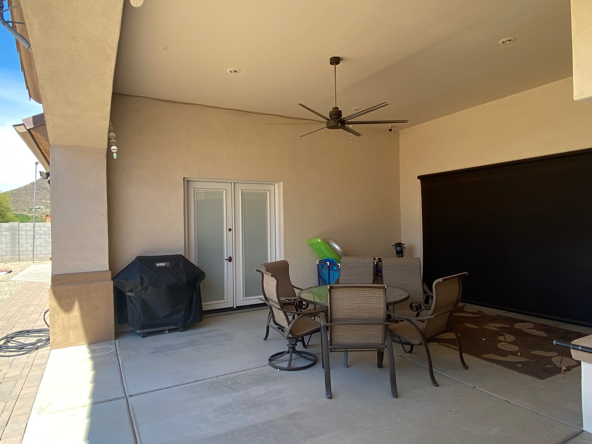 Aurora Estate — bare covered patio before outdoor kitchen, fire feature and TV install