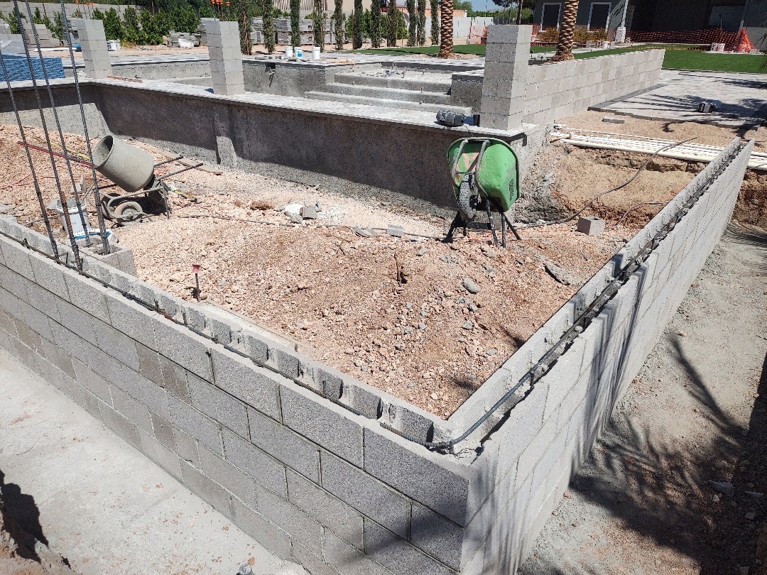Aurora Estate — raised planter block wall with conduit and electrical runs routed through the cap before backfill and finish