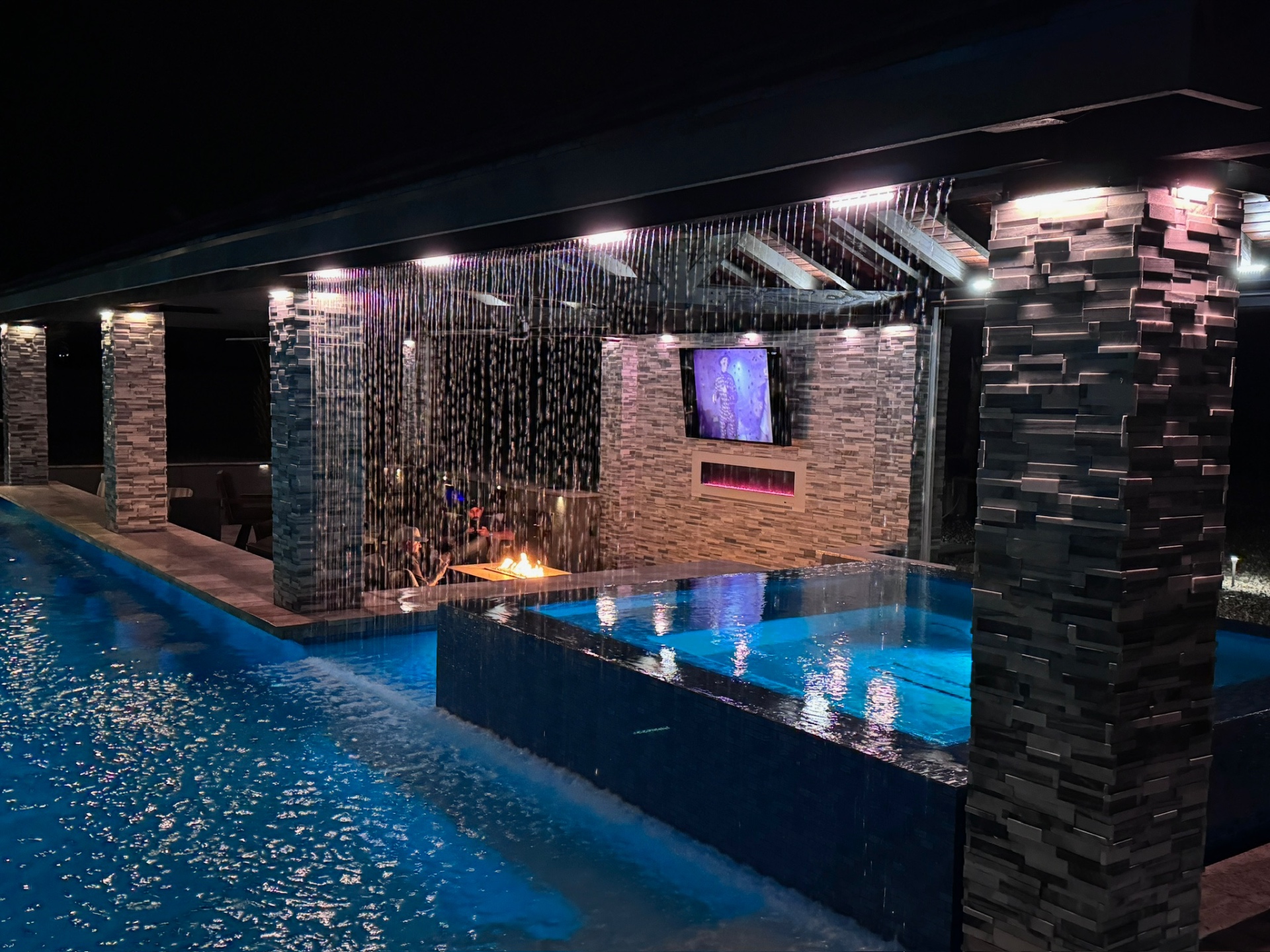 Aurora Estate — rain curtain pavilion with linear fire and outdoor TV