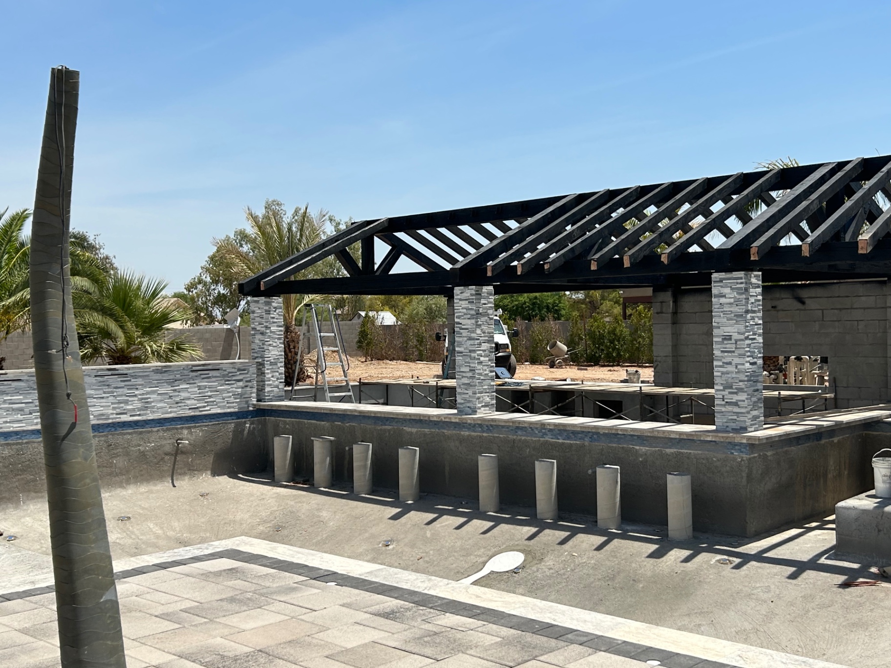 Aurora Estate — close view of the ramada structure, beam work, and column detailing during construction