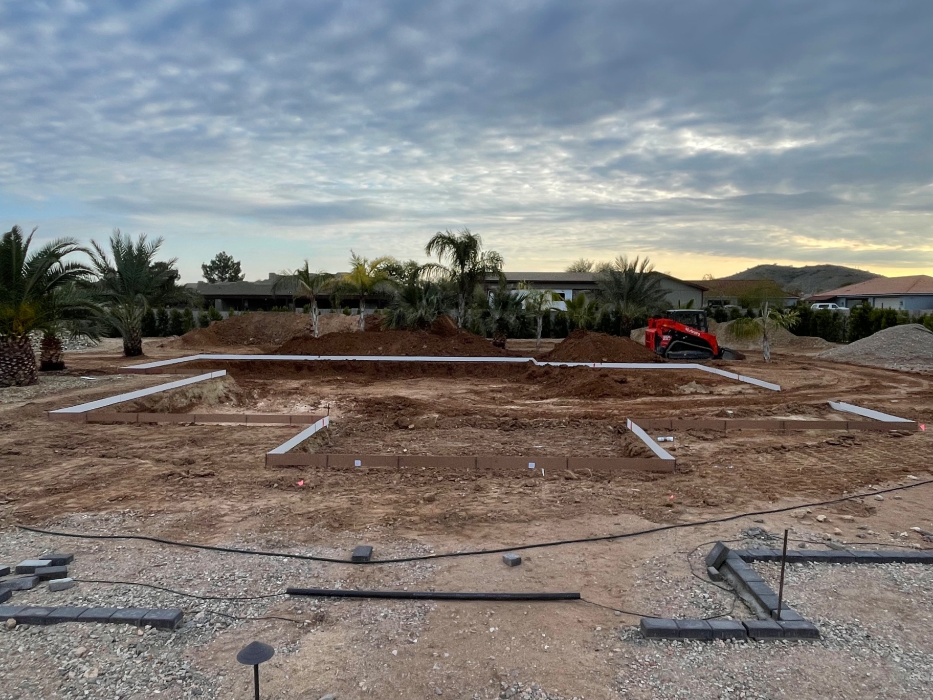 Aurora Estate — alternate dusk angle showing the overall back-yard layout before structural build-out