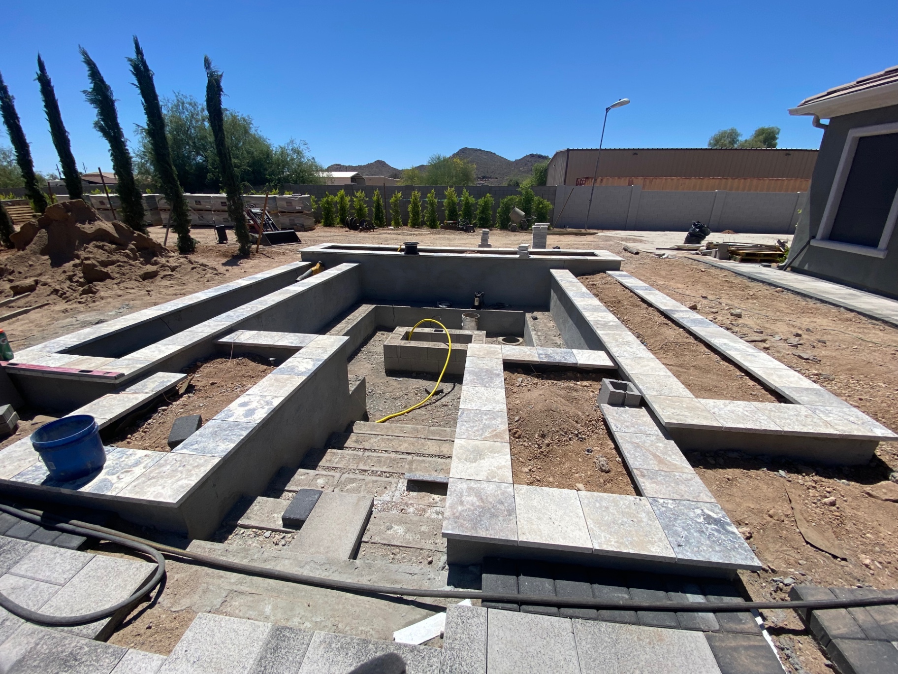 Aurora Estate — raised spa shell and tile coping under construction before finish fill and water