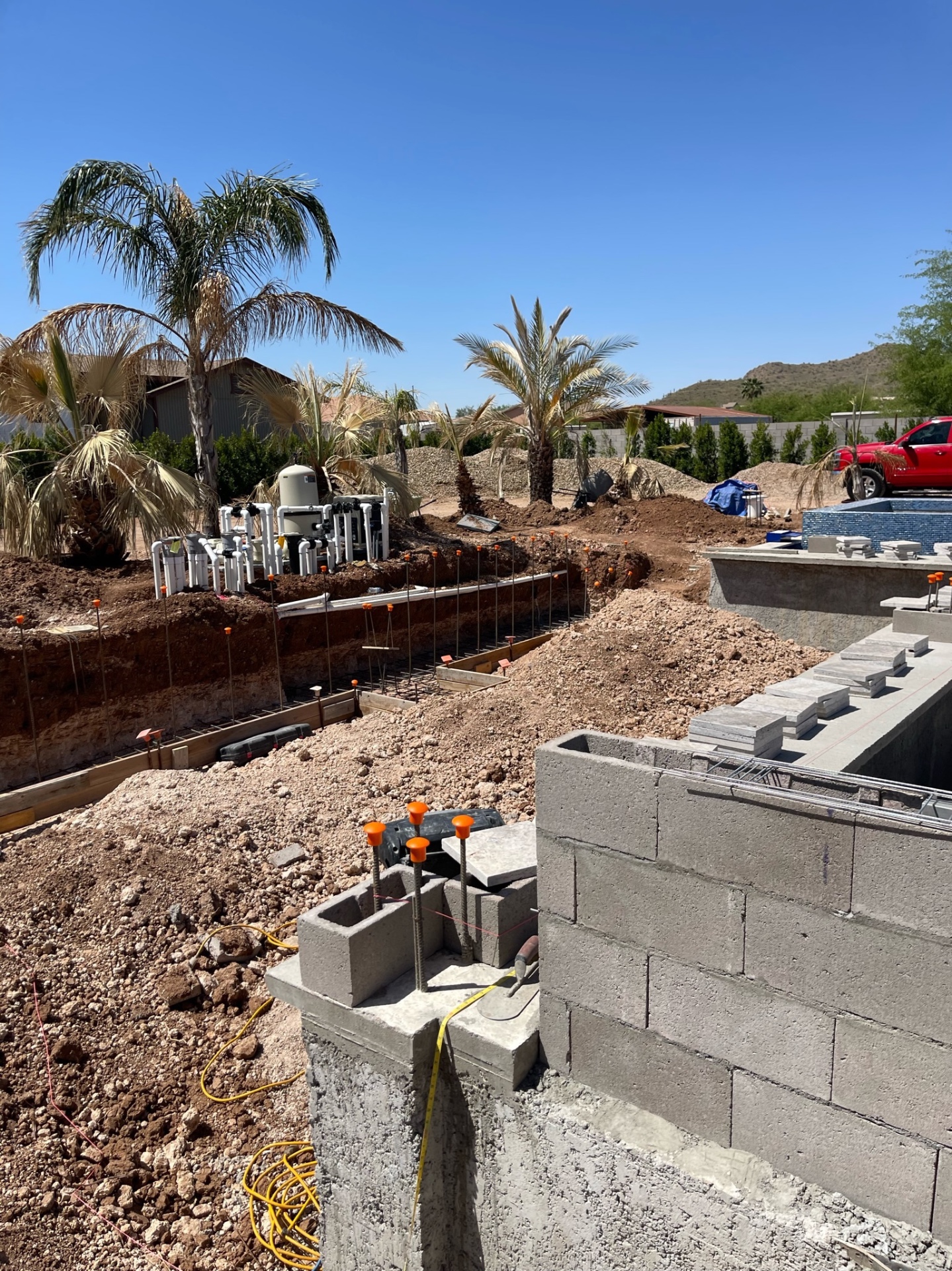Aurora Estate — broad mid-build view showing retaining walls, pool shells, equipment area, and open grade before final hardscape